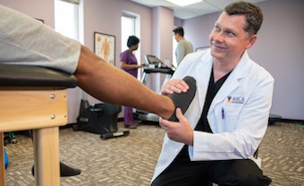 Lithia Springs AICA doctor helping patient's foot with physical therapy