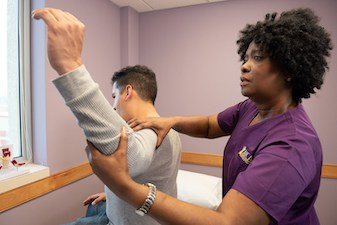 female nurse assisting patient's shoulder injuries